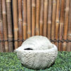 a stone bowl on a green surface